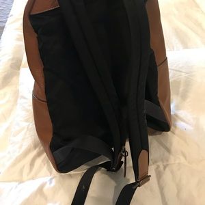 A light brown leather Coach backpack